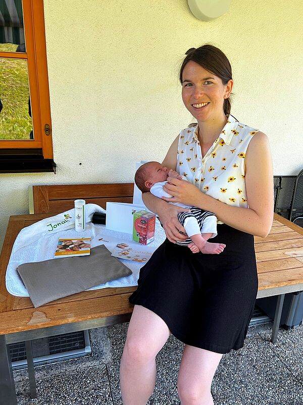 Theresa Loacker und der kleine Jonah neben dem Babypaket. 