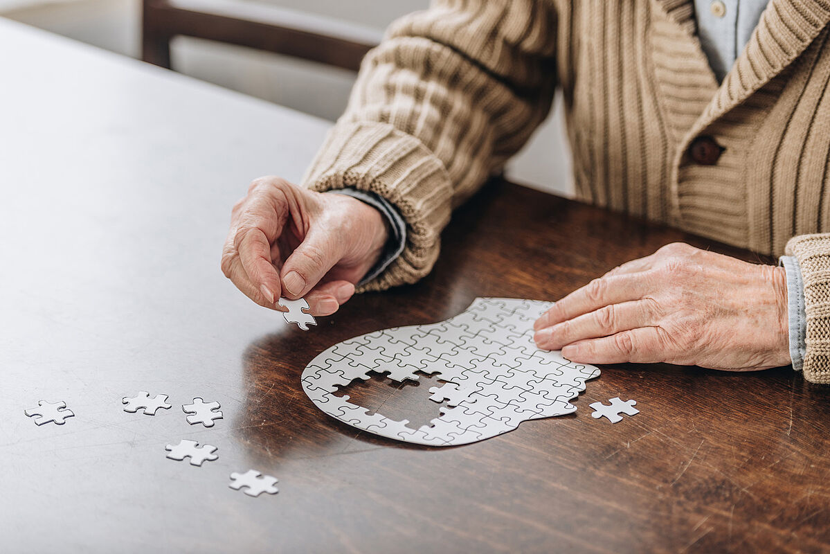 Mann stellt ein Puzzle zusammen, das aussieht wie der Kopf eines Menschen. (Fotoquelle: iStock-LightFieldStudios) 