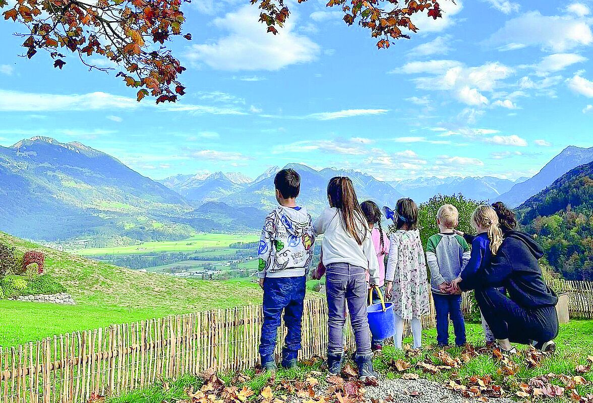 Kinder und Team-Mitglied vom Kindergarten Fellengatter blicken nach Frastanz. 